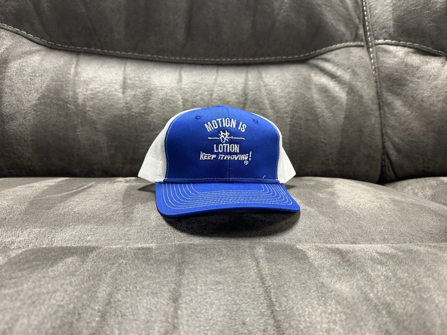 Blue trucker hat: Motion is Lotion.