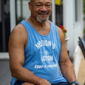 Smiling man in Motion's Lotion tank top.
