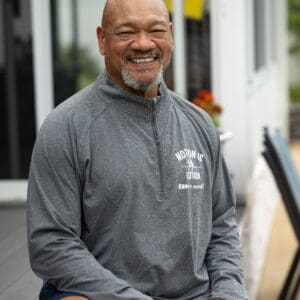 Smiling man wearing Motion is Lotion shirt.