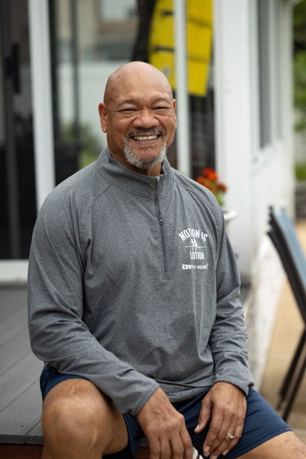 Smiling man wearing Motion is Lotion shirt.