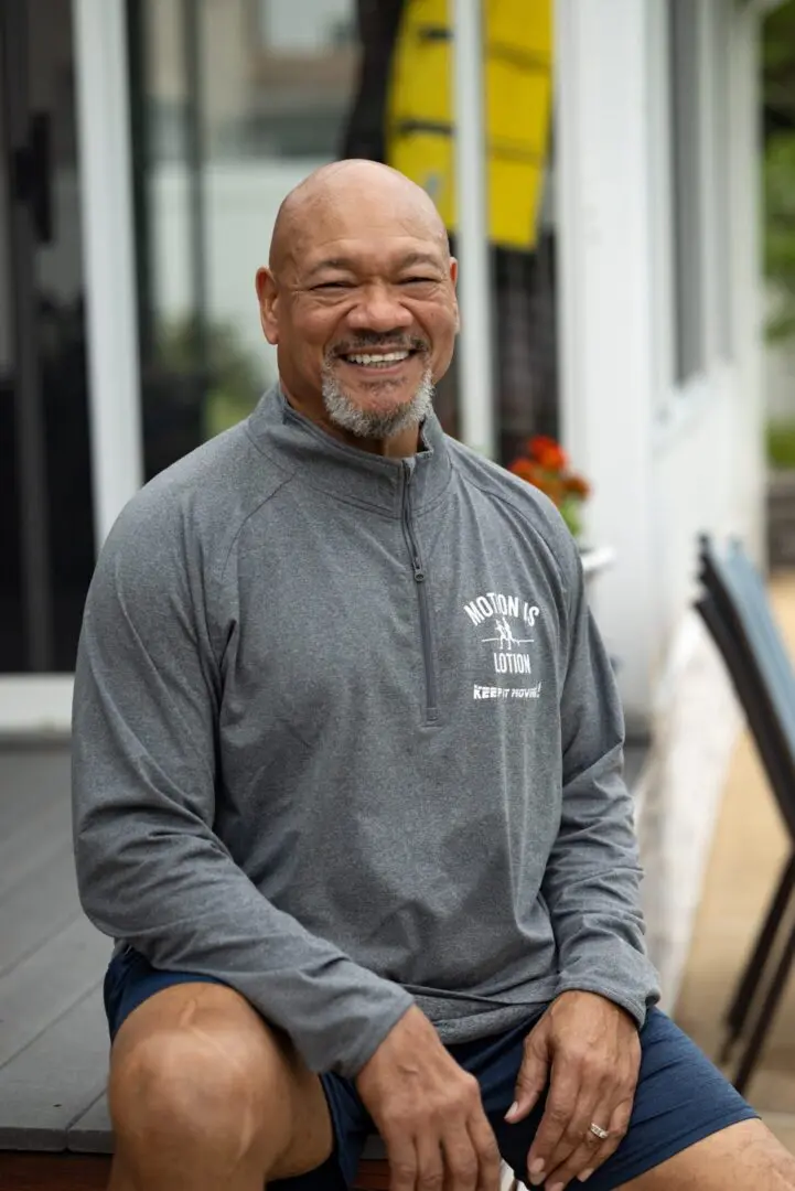 Smiling man wearing Motion is Lotion shirt.